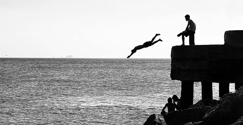 BrandTrust Glossar Commitment - Foto: Silhouetten von Menschen, die vom Steg ins Wasser springen - © Pexels: The Humantra