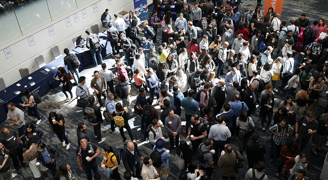 Messehalle mit vielen Besuchenden, die sich unterhalten