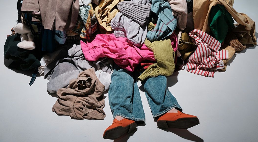 Eine Frau läuft durch einen Supermarkt, vorbei an leeren Regalen (Foto von Martijn Baudoin auf Unsplash)