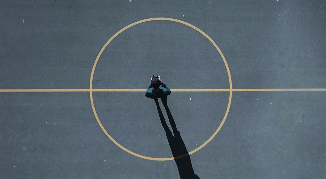 Eine Person steht im Freien in einem Kreis. Das Foto ist von oben fotografiert, sodass man den Kreis, den Kern, gut sehen kann.