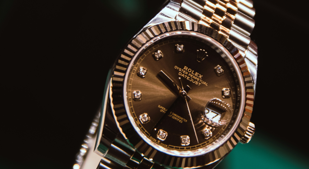 Goldene Rolex Uhr vor dunklem Hintergrund
